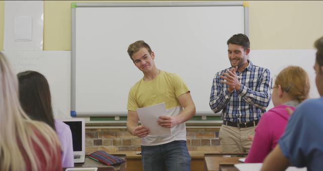 Student gives a presentation in a classroom while the teacher applauds, showcasing educational achievement, teamwork, and academic success. Useful for educational content, school promotional materials, and learning-related articles.