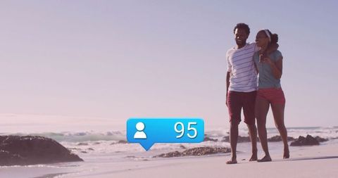 Couple Walking on Beach with Social Media Alert