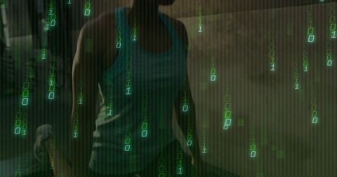 Woman standing in dim room wearing teal-black tank top with neon green binary rain
