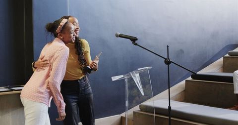 Afro american women hugging at award ceremony