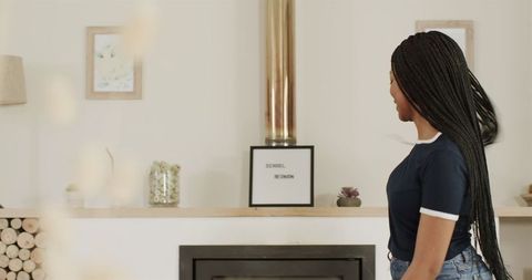 Woman reading lettering on modern fireplace mantel