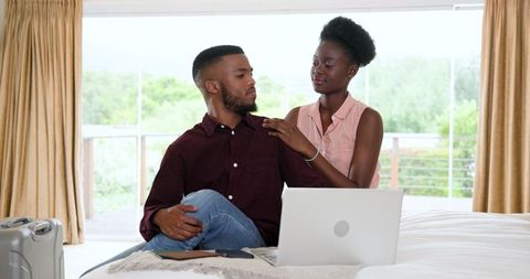 Happy Couple Relaxing on Bed with Laptop, Enjoying Time Together