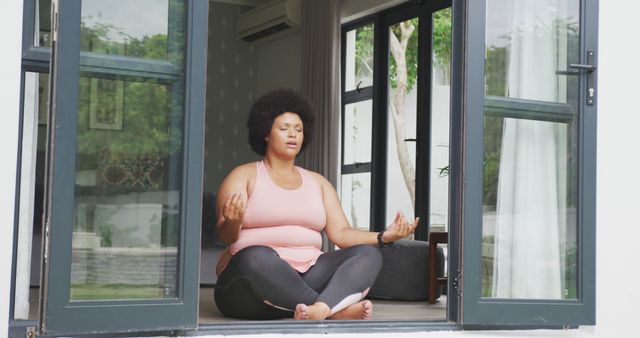 Image of plus size african american woman exercising at home, practicing yoga. active healthy lifestyle, exercising at home.