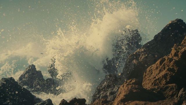 Dynamic ocean wave crashing against rugged coastal rocks
