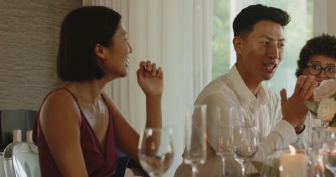 Guests enjoying lively wedding feast indoors