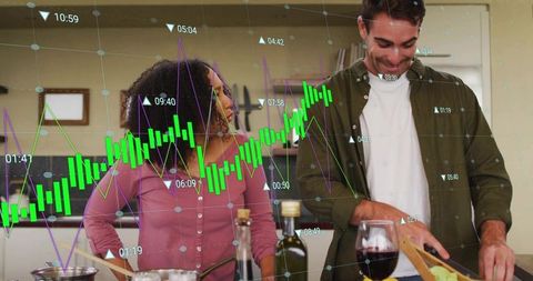 Couple preparing meal together in home kitchen while digital finance charts overlay scene