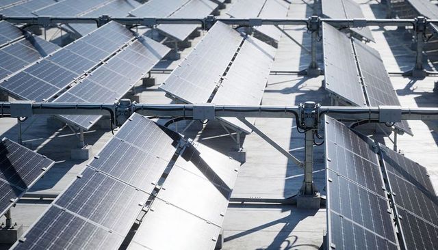 Rooftop Solar Array Reflecting Sunlight with Parallel PV Panel Rows and Mounting Rails