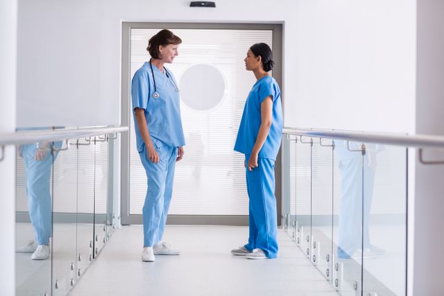 Nurse and doctor interacting with each other in hospital corridor