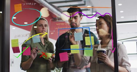 Collaborative Team Brainstorming on Glass Wall with Interface Mockups