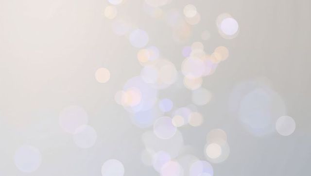 Soft pastel bokeh light orbs floating over muted gray backdrop for elegant web print design