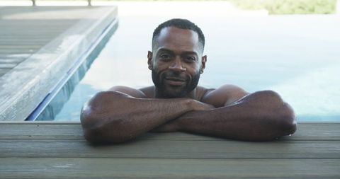 Relaxed man leaning on wooden pool deck with health metrics overlay for wellness