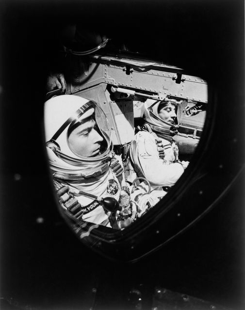 S65-19225 (23 March 1965) --- This view of astronauts John W. Young (left), pilot, and Virgil I. Grissom, command pilot, was taken through the window of the open hatch on Young's side of the Gemini-Titan 3 spacecraft just before the hatches were closed in readiness for their three-orbit flight.