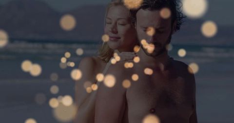 Romantic sunset massage on serene beach with glowing lights