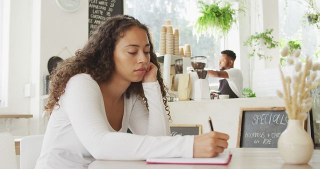 Young Woman Writing in Notebook at Cozy Cafe - Download Free Stock Images Pikwizard.com