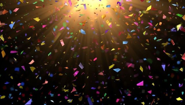 Multicolored confetti under spotlight on dark stage