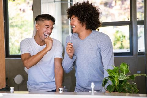 Diverse Friends Brushing Teeth and Laughing in Modern Bathroom