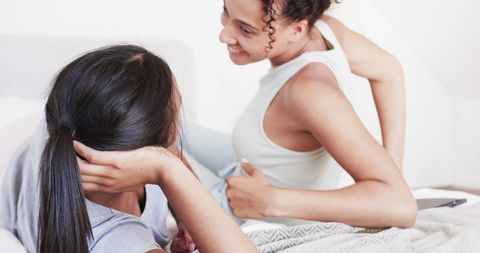 Joyful Biracial Lesbian Couple in Bedroom