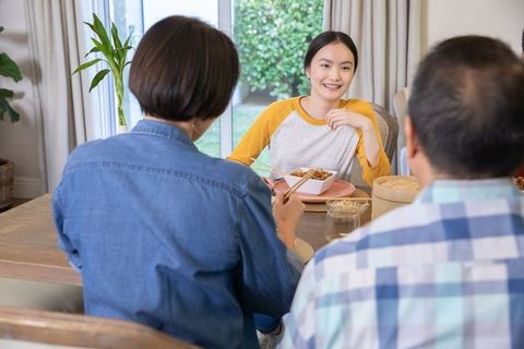 Asian family joyfully sharing a traditional meal at home