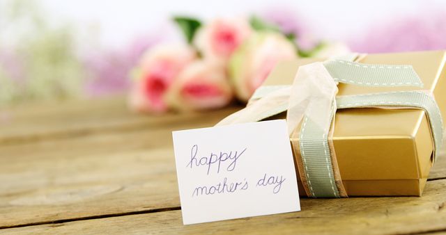 Close-up of gift box with happy mother day card on wooden surface