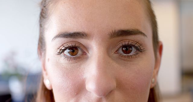 Close-up of a woman showcasing heterochromia, where her eyes are different colors. Useful for illustrating articles about genetics, eye conditions, and human diversity. Ideal for health, beauty, and medical websites or campaigns emphasizing uniqueness and diversity.