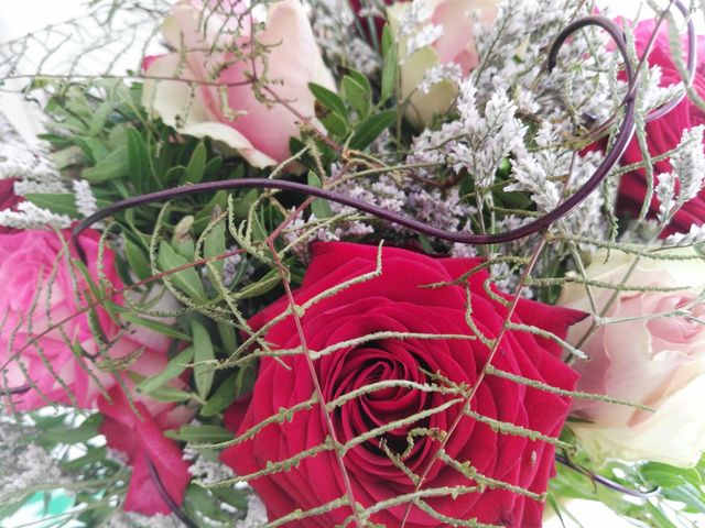 Close-up of gorgeous bouquet with red and pink roses, intricate greenery, and delicate white flowers, perfect for weddings, anniversaries, Valentine's Day, Mother’s Day, or other romantic events. Can be used in floral design presentations, greeting cards, or promotional materials for florists.
