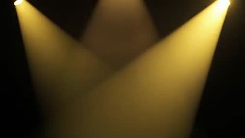 Warm Golden Spotlights Illuminating Hazy Stage