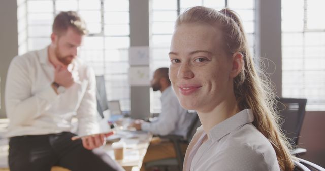 Smiling Businesswoman in Modern Open Office Space with Colleagues Working - Download Free Stock Images Pikwizard.com