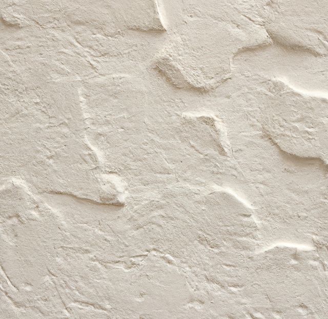 This textured beige plaster wall surface showcases a rough and organic pattern. It is ideal for use in interior design projects, construction presentations, and as a neutral background for various designs or advertisements.