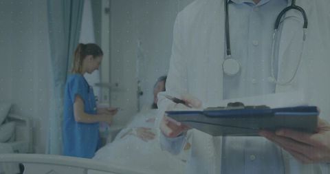 Doctor with Clipboard Providing Patient Care in Hospital Room