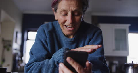 Senior Woman Communicating via Smartphone at Home