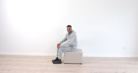Athletic Man in Gray Tracksuit Using Ottoman for Indoor Workout - Download Free Stock Images Pikwizard.com