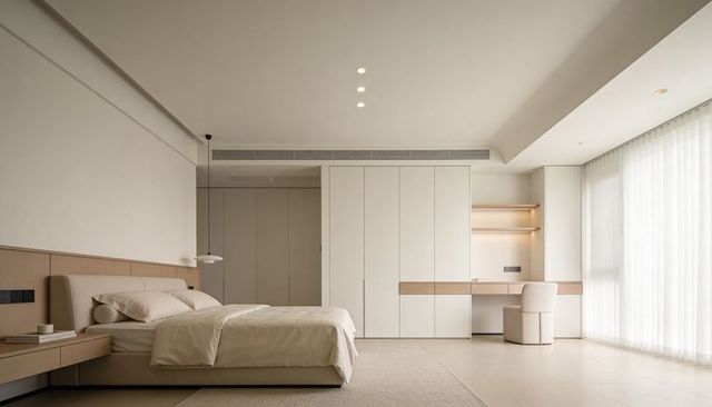 Minimalist neutral bedroom with low upholstered bed, built-in desk and sheer curtains