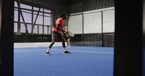 Man Playing Padel Tennis Indoors Enjoying the Game