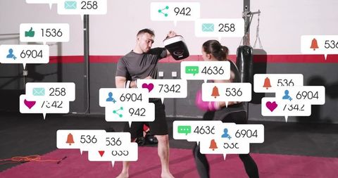 Coach holding focus mitts guiding boxer punching with social media overlays for gym marketing