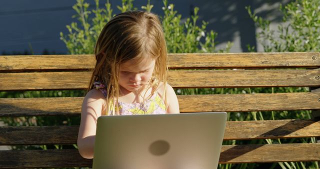 Young Girl Concentrating on Laptop While Sitting on Outdoor Bench - Download Free Stock Images Pikwizard.com