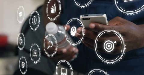 Worker tapping smartphone while digital analytics and interface icons floating over scene