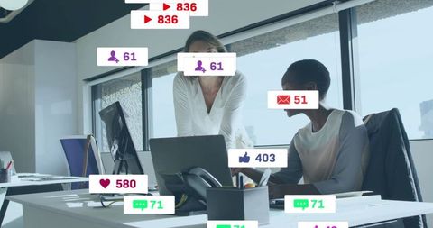 Collaborating over laptop with social media notification overlays in modern office