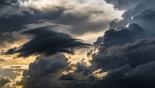Dramatic Backlit Cumulonimbus Thunderhead with Anvil Cloud and Silver Linings at Sunset