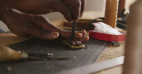 Leather Craftsman Handcrafting Belt Detail in Workshop