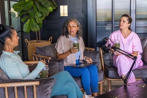 African american nurses recording podcast drinking green smoothies in cozy lounge
