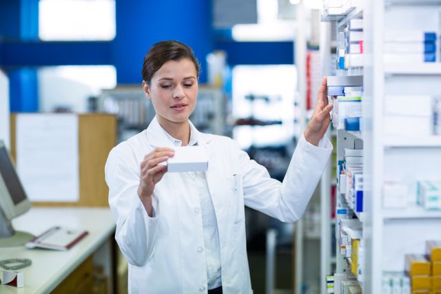 Pharmacist in white coat checking medicine on shelf in pharmacy. Ideal for illustrating healthcare, pharmaceutical industry, medical professionals, and pharmacy operations. Useful for articles, advertisements, and educational materials related to pharmacy and medication management.