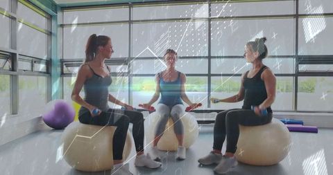 Women Exercising on Stability Balls in Bright Fitness Studio