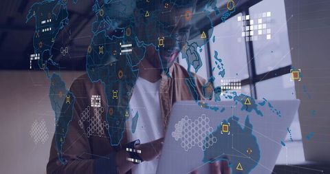 Data analyst working on laptop with global map interface overlay