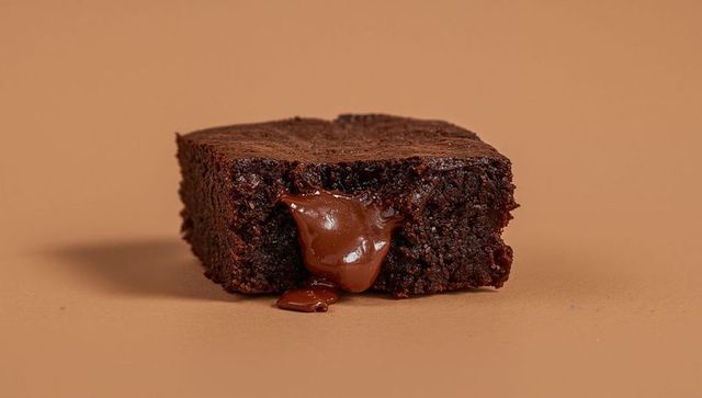 Gooey Chocolate Brownie Square Oozing Molten Filling on Neutral Beige Background