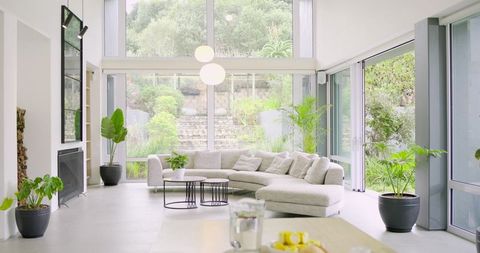 Sunlit Minimalist Living Room with L-Shaped Sectional Sofa and Floor-to-Ceiling Windows