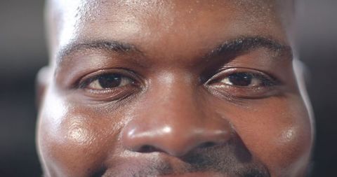 Close-up portrait of African American man showing skin texture, intense gaze, mustache