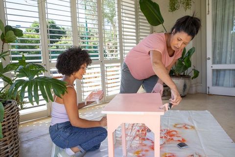 Mother and daughter bonding over diy table painting project