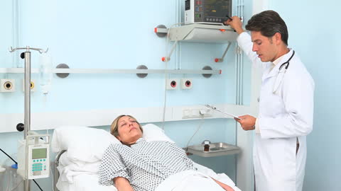 Doctor attending to patient in hospital ward doing routine check-up