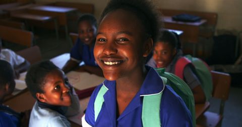 Joyful african american schoolgirl smiling in classroom setting