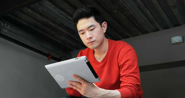 Young Man Using Digital Tablet in Modern Industrial Space - Download Free Stock Images Pikwizard.com